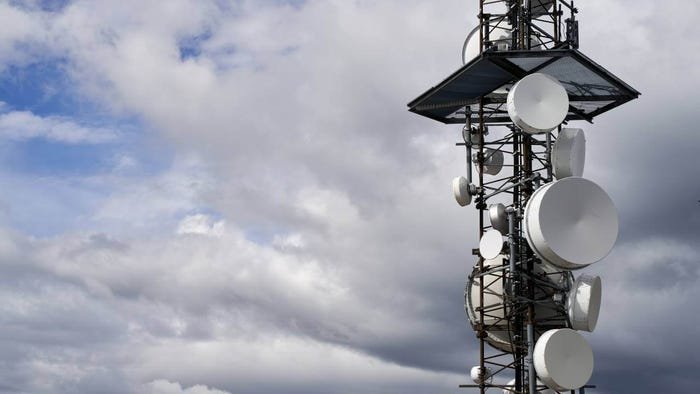 Telecommunications towers against cloudy sky