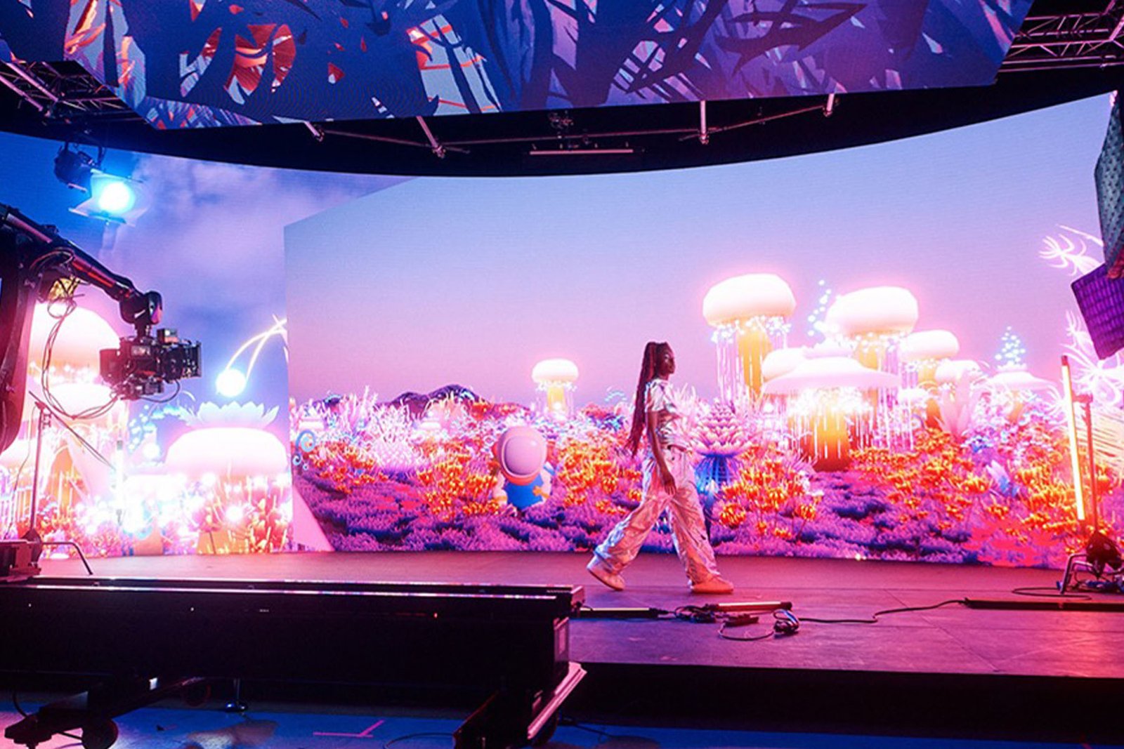 Woman walking in front of a colourful screen